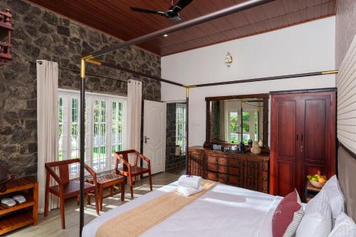 1 dormitorio con 1 cama, mesa y sillas en 31st December Farms And Estates Munnar en Munnar