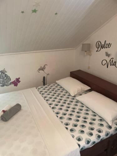 a bedroom with two beds and a sign on the wall at Charmant T3 avec Terrasse et Vue sur Mer in Le Marin
