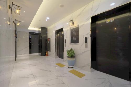a hallway with a potted plant in a building at HOTEL YUNA Business in Busan