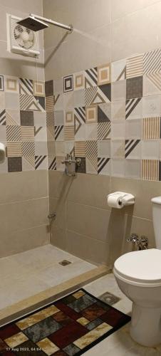 a bathroom with a toilet and a glass shower at Crystal pyramid inn in Cairo