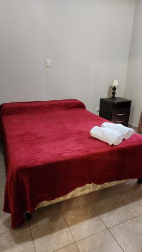 a bedroom with a red bed with two towels on it at Brown Alojamientos Temporarios in Salta