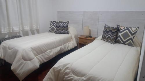 duas camas sentadas uma ao lado da outra num quarto em B&G APART BELGRANO em Río Cuarto