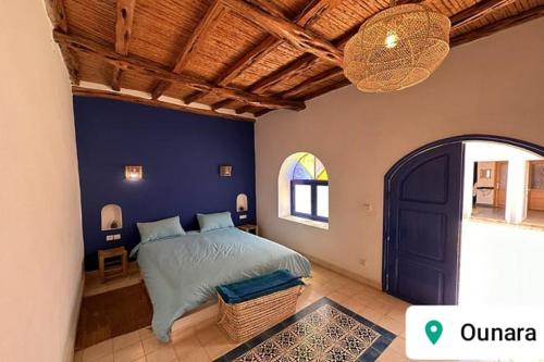 um quarto com uma cama e uma parede azul em Villa Dar Ma Ma (Ounagha) em Essaouira