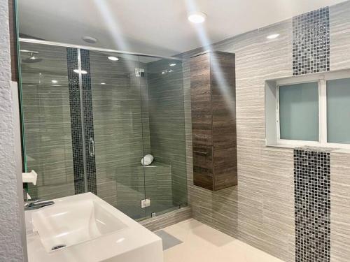 a bathroom with a sink and a glass shower at Executive House Miami, Close to Airport, Beach in Miami