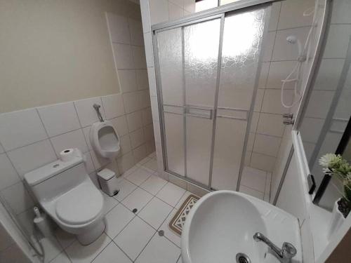 een witte badkamer met een toilet en een douche bij Departamento frente a parque in Lima