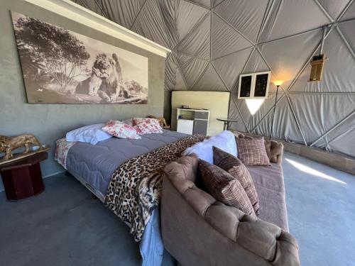 1 dormitorio con 1 cama y 1 sofá en una tienda de campaña en Refúgio Santa Helena - Domo Safari en Salesópolis