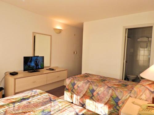 a hotel room with two beds and a mirror at Hotel Tres Cruces in Montevideo