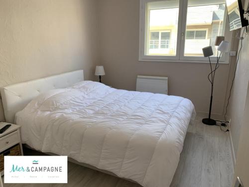 un lit blanc dans une chambre avec une fenêtre dans l'établissement Appartement rénové avec garage privé, balcon et vue mer - FR-1-482-87, à Fort-Mahon-Plage