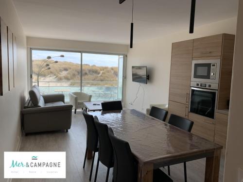 une cuisine et une salle à manger avec une table et des chaises dans l'établissement Appartement rénové avec garage privé, balcon et vue mer - FR-1-482-87, à Fort-Mahon-Plage