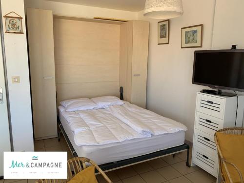 une petite chambre avec un lit et une télévision à écran plat dans l'établissement Studio cosy à 70m de la plage avec balcon exposé nord - Proche commerces et restaurants - FR-1-482-88, à Fort-Mahon-Plage