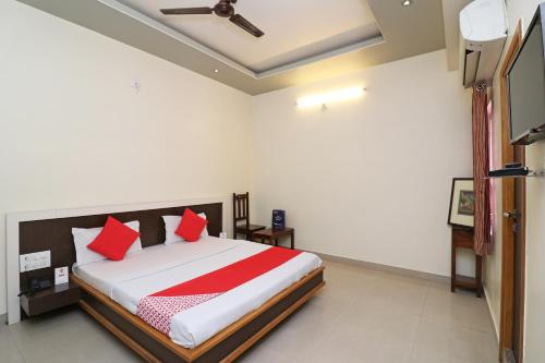 a bedroom with a bed with red pillows at OYO 16646 Hotel Jyoti in Bikaner