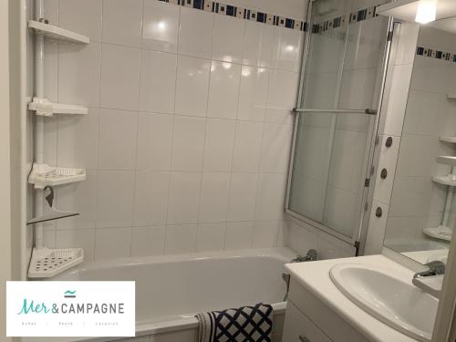 une salle de bain blanche avec une baignoire et un lavabo dans l'établissement Appartement T2 Cabine Proche Plage avec Balcon et Parking Privé - FR-1-482-110, à Fort-Mahon-Plage
