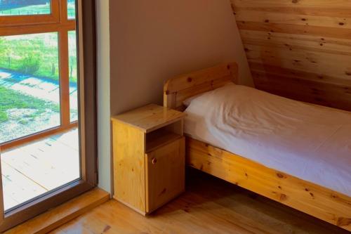 a small bedroom with a bed and a window at Chalet Čilac in Žabljak