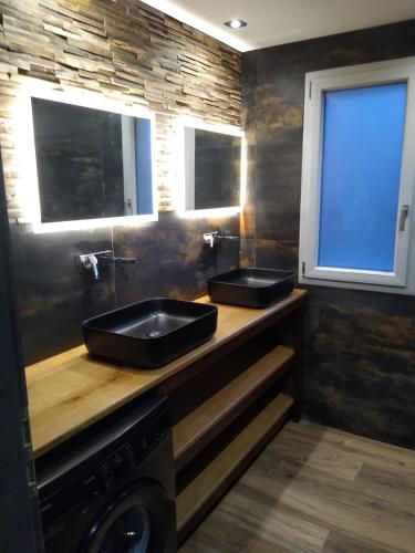 deux lavabos sur un comptoir en bois dans une salle de bain dans l'établissement Superbe Chalet Neuf, à Cornimont