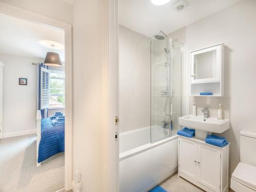 a white bathroom with a shower and a sink at Elwell Cottage in Beverley