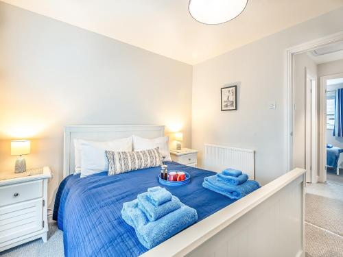 a bedroom with a bed with blue towels on it at Elwell Cottage in Beverley
