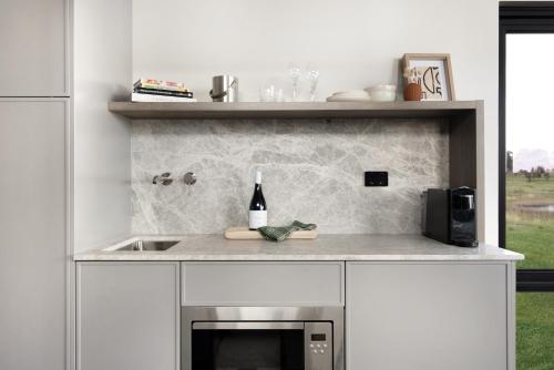 a kitchen with a sink and a counter with a bottle of wine at The Lane Retreat in Pokolbin