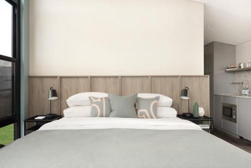 a bedroom with a large white bed with pillows at The Lane Retreat in Pokolbin