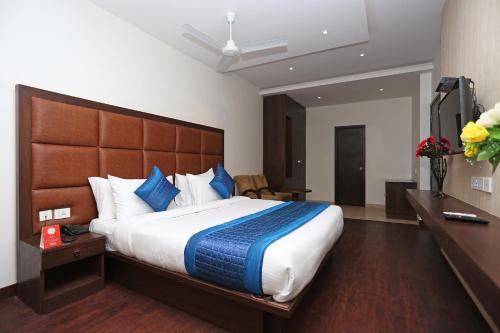 a bedroom with a large bed with a wooden headboard at OYO Asian Hospitality Near Aravali Biodiversity Park in Gurgaon