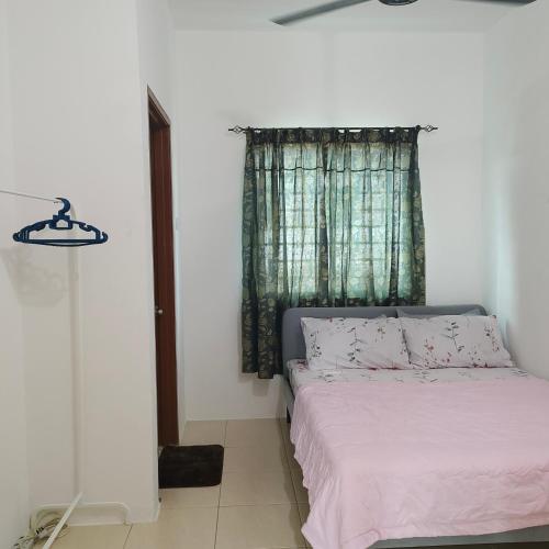 1 dormitorio con 1 cama y una ventana con sábanas rosas en Ummik Homestay, en Tawau