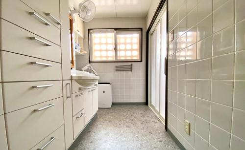 a small bathroom with a sink and a window at ポンツーン in Ishigaki Island