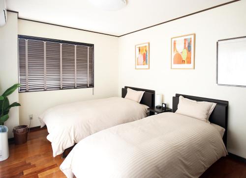 石垣島的住宿－ポンツーン，卧室内两张并排的床