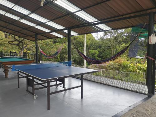 a ping pong table in a pavilion with a hammock at Villa tata Granja autosostenible in Sasaima