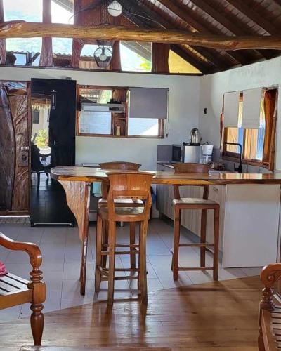 a kitchen with wooden stools and a wooden table at Le Village de Vairao in Vairao