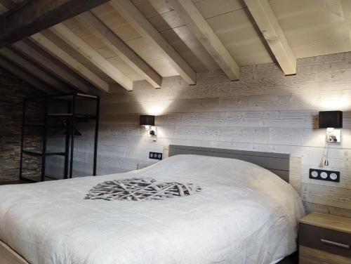 - une chambre avec des murs blancs et un grand lit dans l'établissement Superbe Chalet Neuf, à Cornimont