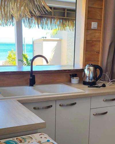 a kitchen counter with a sink and a window at Le Village de Vairao in Vairao
