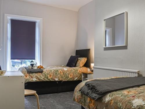 a hotel room with two beds and a window at Lavender House in Barnoldswick