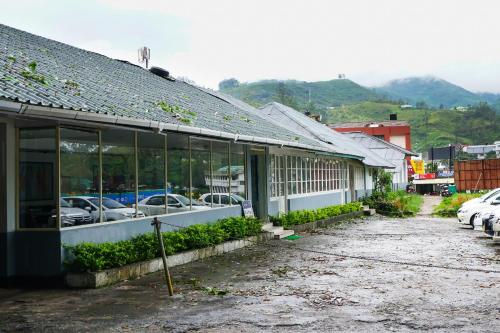 a building with cars parked in a parking lot at OYO Hotel Merimaid in Munnar