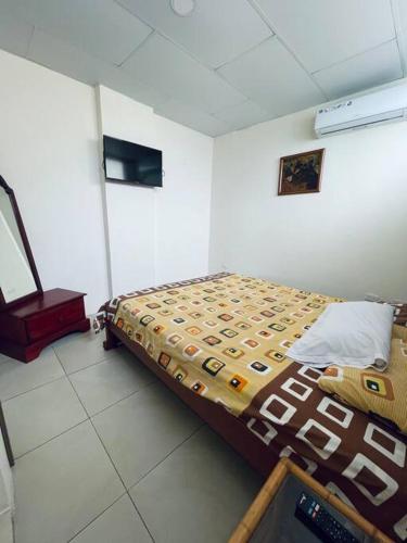 um quarto com uma cama e um computador portátil em Cómoda Suite cerca de todo em Guayaquil