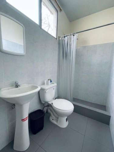 uma casa de banho branca com um lavatório e um WC em Cómoda Suite cerca de todo em Guayaquil