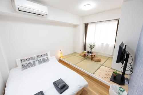 a small room with a bed and a tv at 今和Hotel in Tokyo