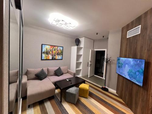 ein Wohnzimmer mit einem Sofa und einem TV in der Unterkunft Tumanyan Apartments in Yerevan