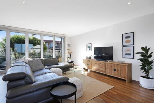 a living room with a couch and a flat screen tv at Silver Ball Retreat in Warrnambool