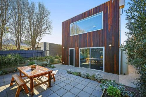 une maison en bois avec une table et des bancs en bois dans l'établissement Silver Ball Retreat, à Warrnambool