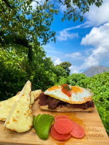 Una tabla de cortar de madera con un sándwich con huevo y pan. en Casa 1800 Cerro Verde, en Cerro Verde