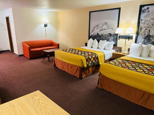 a hotel room with two beds and a chair at Super 8 by Wyndham Hot Springs in Hot Springs