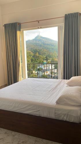 a bedroom with a bed and a large window at Golden sky in Kandy