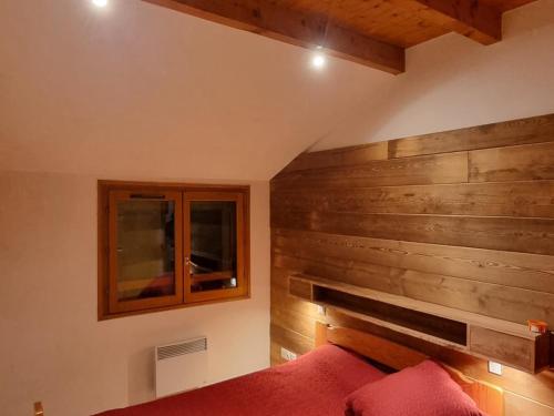 - une chambre avec un mur en bois et un lit dans l'établissement Spacieux duplex cœur Valloire, 12 pers, proche remontées et commerces - FR-1-263-528, à Valloire