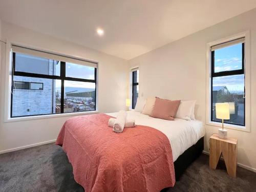 1 dormitorio con 1 cama grande y 2 ventanas en CHCH centre Luxury townhouse close to CBD, en Christchurch