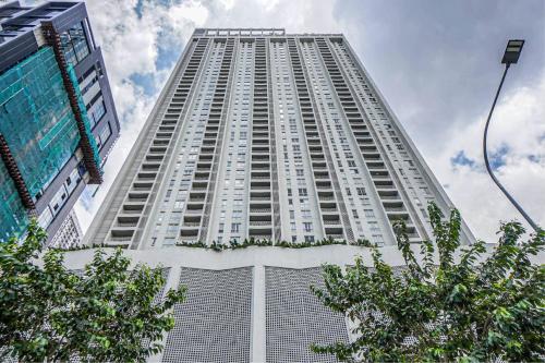 a tall white building with trees in front of it at UNA Sunway Velocity Kuala Lumpur by Unimax in Kuala Lumpur