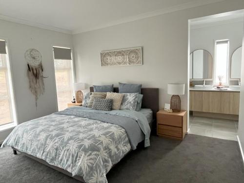 a bedroom with a large bed and a mirror at Surrey View in Narrawong