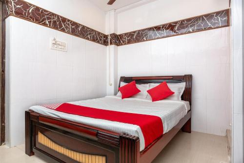 een slaapkamer met een bed met rode kussens bij OYO 19396 Cristal Residency in Chennai