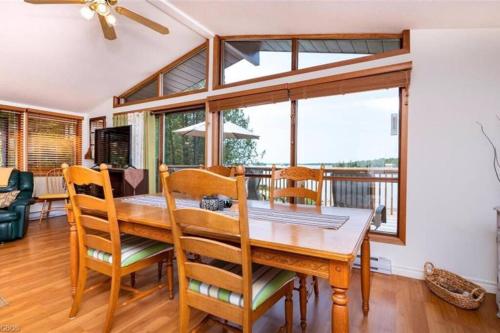 a dining room with a table and chairs and a balcony at Waterfront Cottage for rent (Near Sauble Beach) in Wiarton