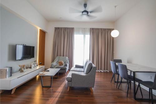 a living room with a couch and a table with chairs at UNA Sunway Velocity Kuala Lumpur by Unimax in Kuala Lumpur