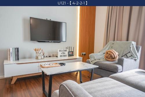 a living room with a tv and a couch and a table at UNA Sunway Velocity Kuala Lumpur by Unimax in Kuala Lumpur