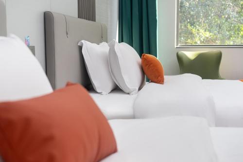 a group of pillows on a bed in a room at Guangzhou Yashay International Apartment - Pazhou Convention and Exhibition Centre in Guangzhou
